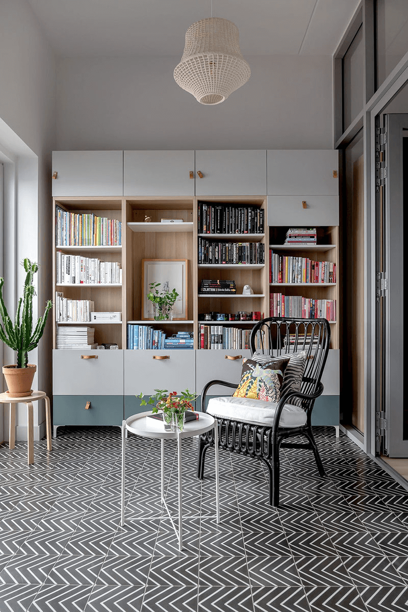 this is a classic Scandinavian room with wooden cabinets, a chair with a cushion and house plants