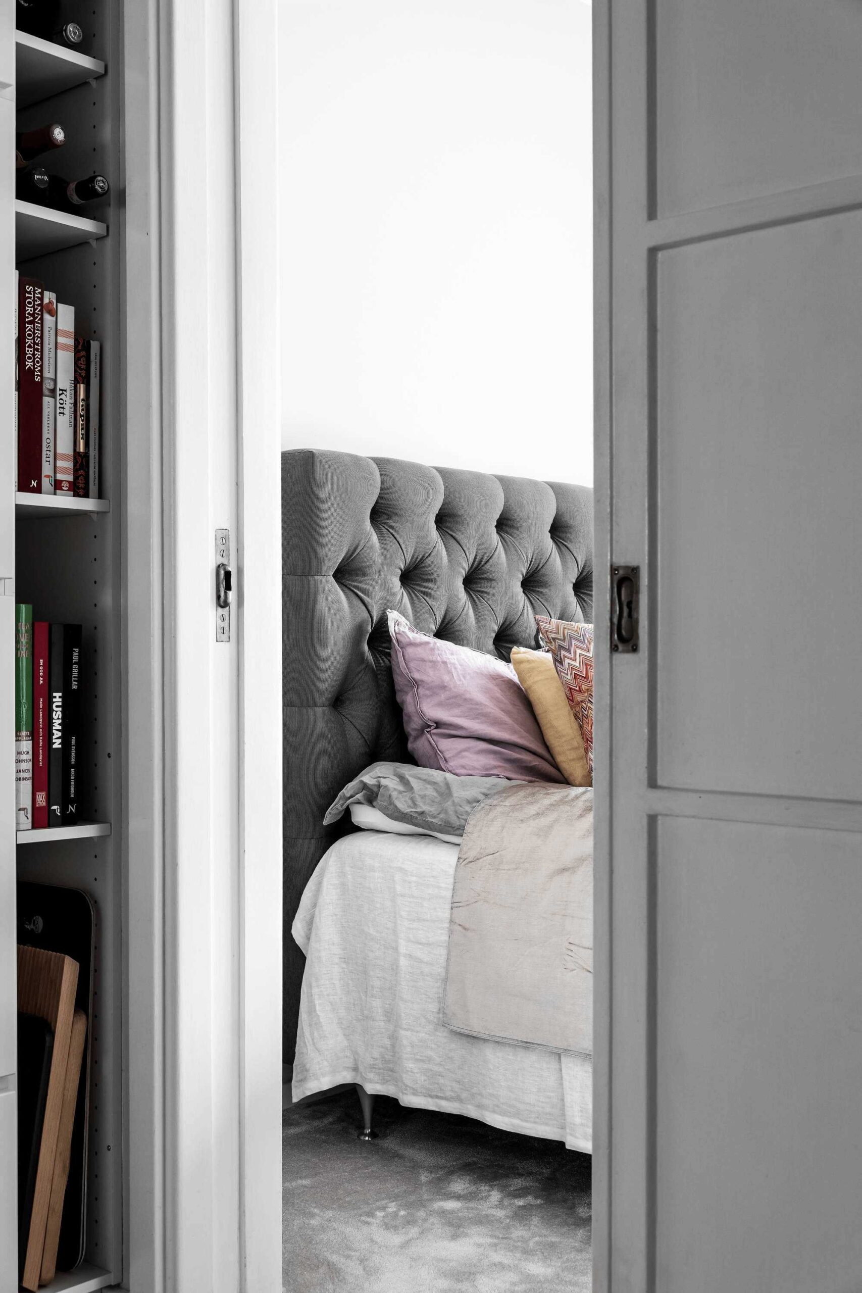 this-is-a-look-at-a-bed-in-a-scandinavian-apartment-with-a-bookshelf-on-the-side-to-show-the-small-initimate-space