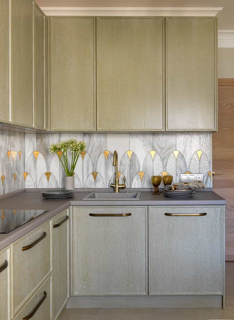 this is an art deco inspired kitchen with gold and silver tiles